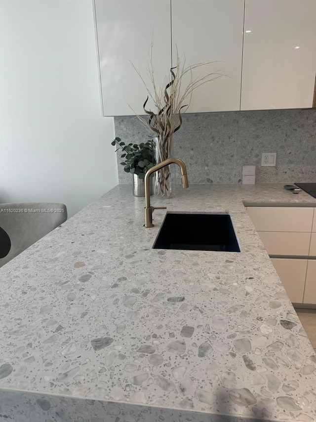2678 Tigertail Ave Unit 515, Miami, FL 33133 - room details featuring tasteful backsplash, modern cabinets, a sink, light stone counters, and white cabinetry