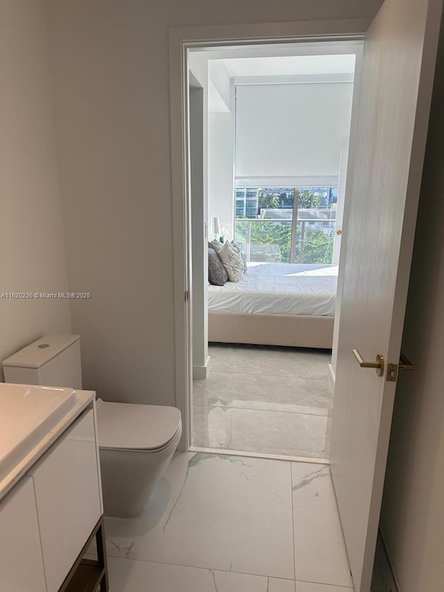 2678 Tigertail Ave Unit 515, Miami, FL 33133 - ensuite bathroom featuring vanity, connected bathroom, baseboards, and toilet