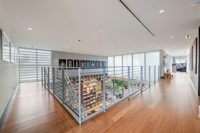 corridor featuring expansive windows and hardwood / wood-style floors