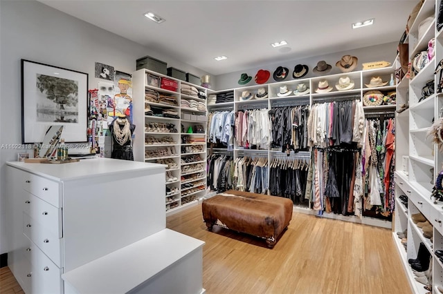 walk in closet with light hardwood / wood-style floors