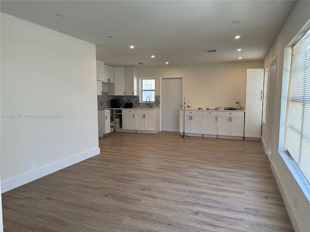 kitchen with hardwood / wood-style floors, white cabinets, and plenty of natural light