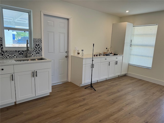 kitchen with white cabinets, hardwood / wood-style flooring, and sink