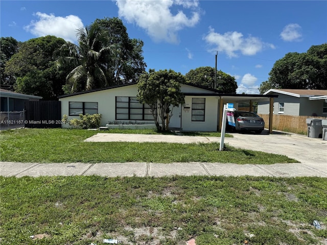 view of front of house featuring a front lawn and a carport