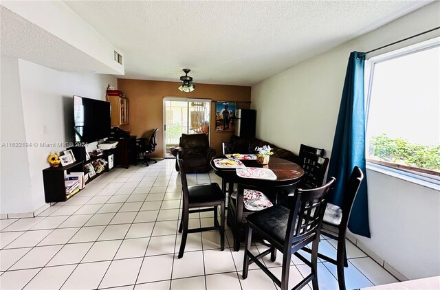 tiled dining area featuring a textured ceiling