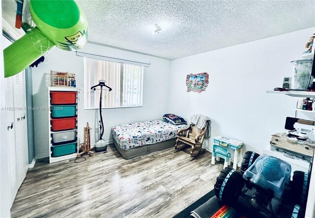 bedroom with a textured ceiling and hardwood / wood-style floors