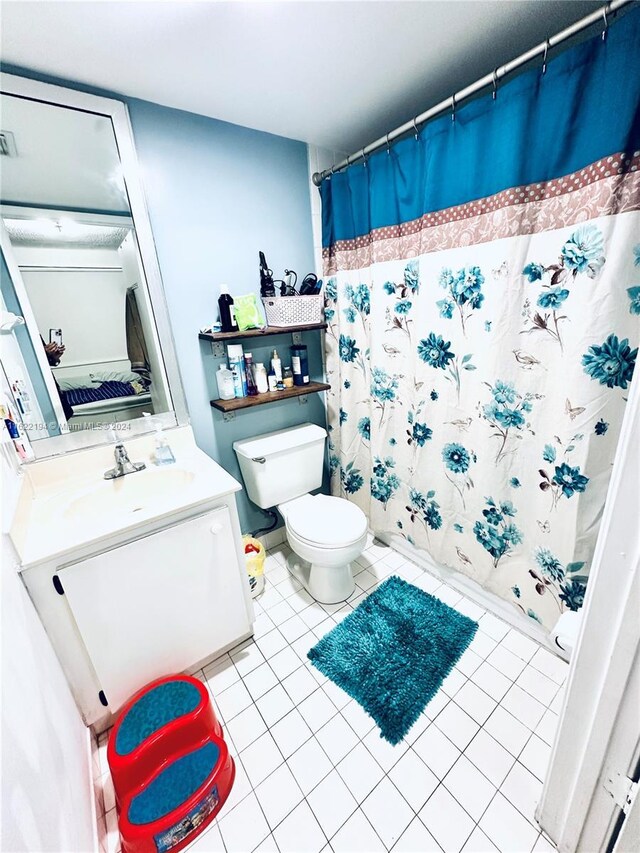 bathroom with a shower with shower curtain, tile patterned flooring, vanity, and toilet