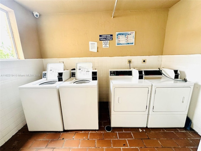 washroom with tile walls and washing machine and clothes dryer