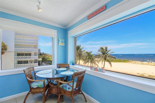 sunroom featuring a water view