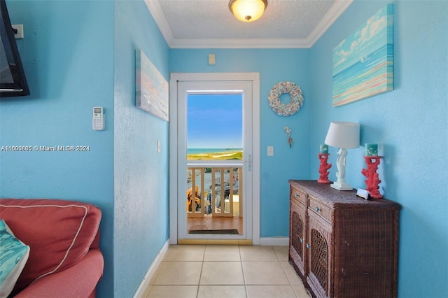 tiled entrance foyer with crown molding and a textured ceiling