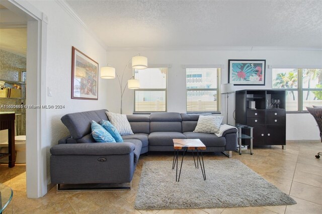 living room featuring ornamental molding, a textured ceiling, and tile patterned floors