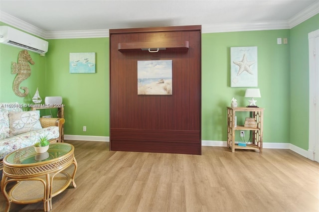 living area with a wall mounted AC, crown molding, and hardwood / wood-style floors