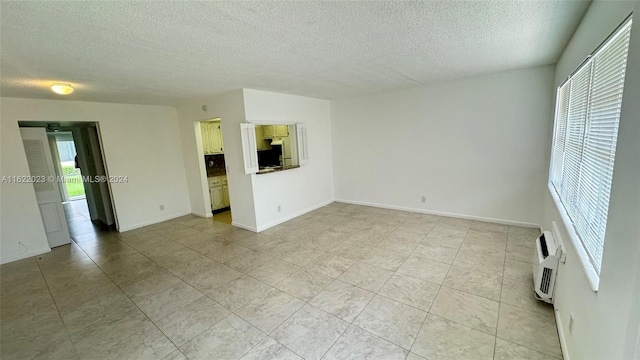 empty room with light tile patterned flooring and a textured ceiling