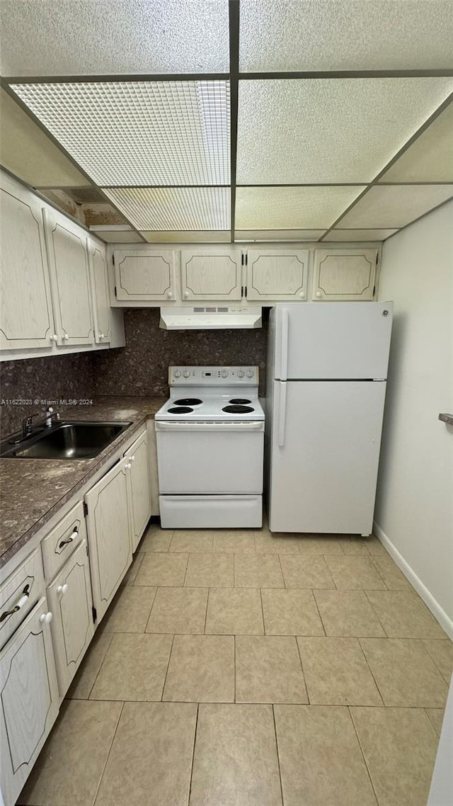 kitchen with a paneled ceiling, tasteful backsplash, sink, light tile patterned floors, and white appliances