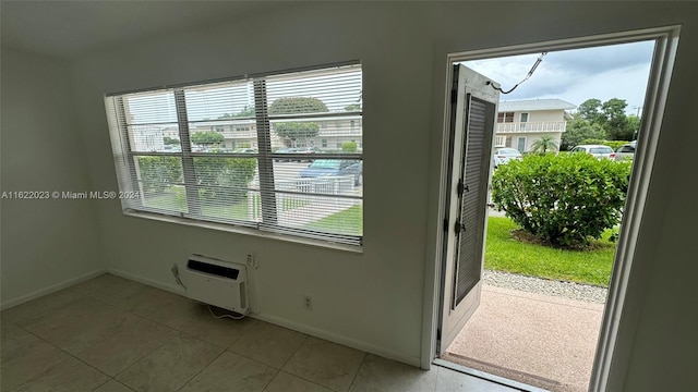 doorway to outside with light tile patterned flooring, a wall unit AC, and heating unit