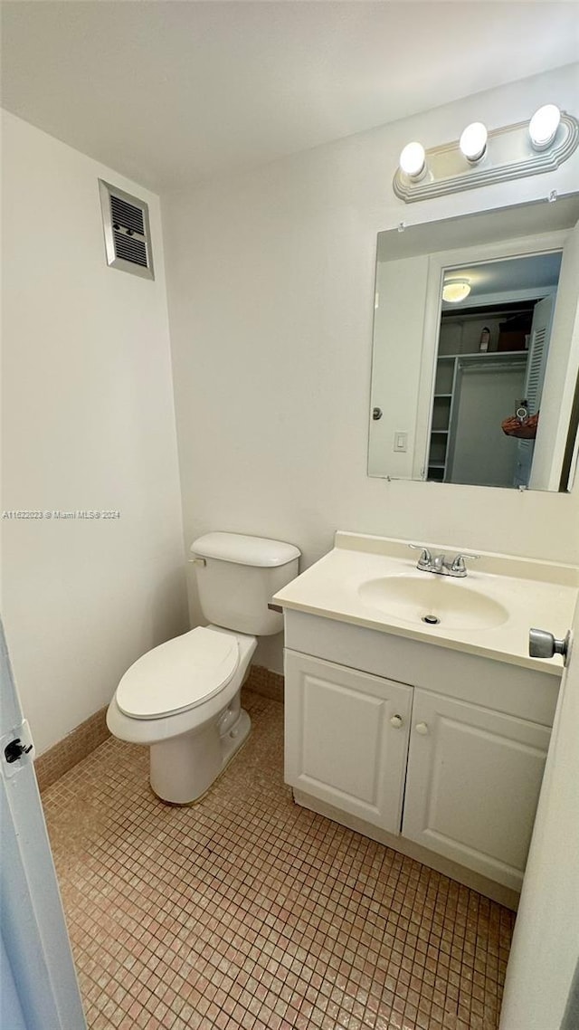 bathroom with vanity, tile patterned flooring, and toilet