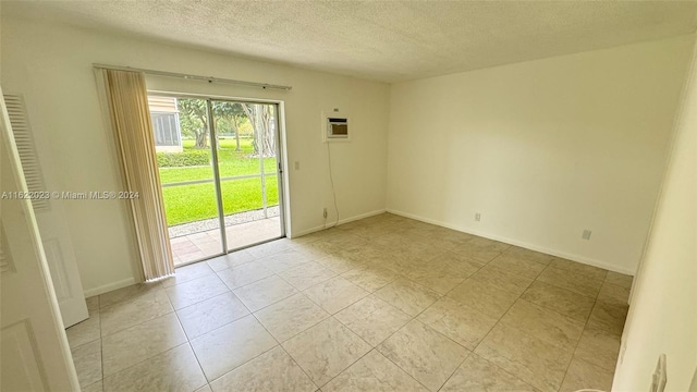 spare room with a wall mounted AC and a textured ceiling