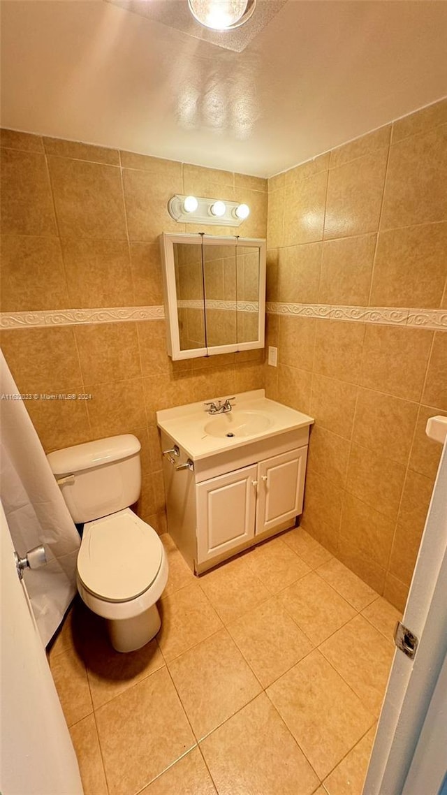 bathroom featuring vanity, tile walls, tile patterned floors, and toilet