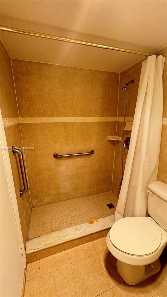 bathroom with toilet, tile patterned floors, and walk in shower