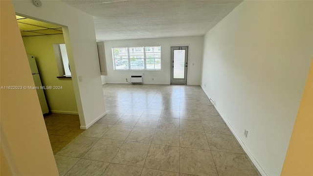 hall featuring a textured ceiling and light tile patterned floors