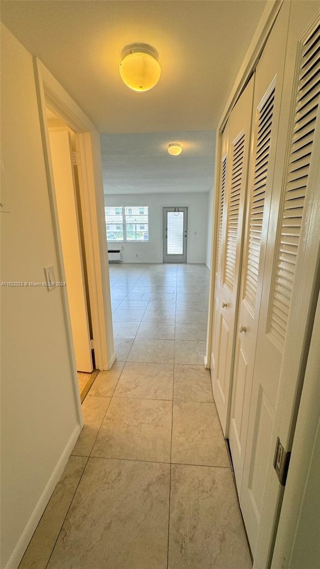 hall with light tile patterned floors