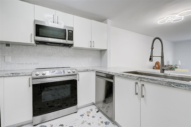 kitchen featuring stainless steel appliances, tasteful backsplash, sink, and white cabinets