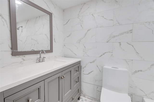 bathroom with vanity, toilet, and tile walls