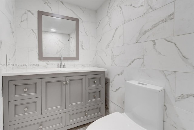 bathroom featuring tile walls, vanity, and toilet