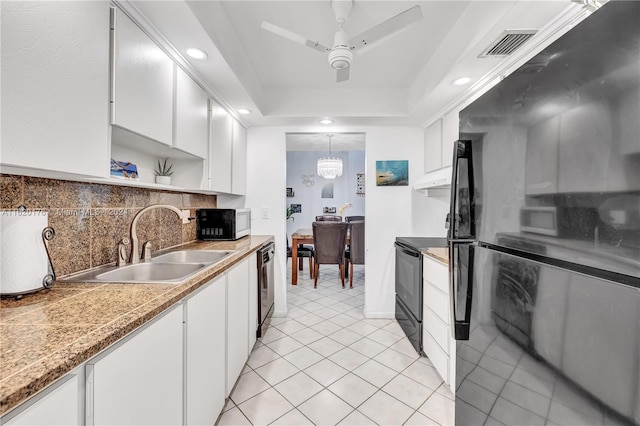 kitchen with white cabinetry, sink, decorative light fixtures, and black appliances