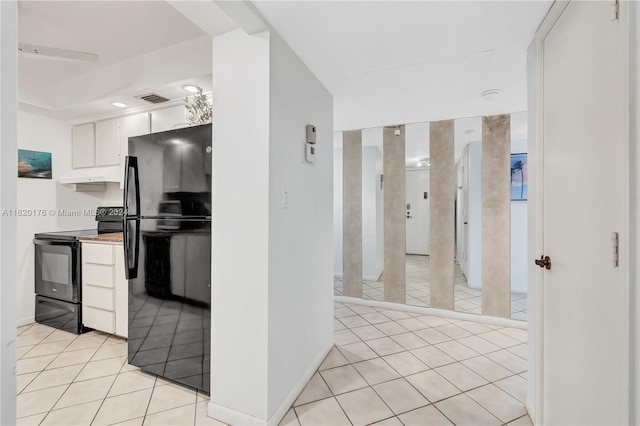 kitchen featuring white cabinetry, light tile patterned floors, and black appliances