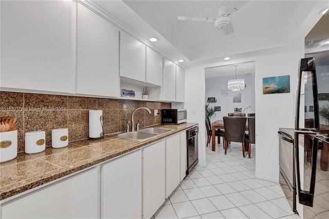 kitchen with sink, hanging light fixtures, light tile patterned floors, decorative backsplash, and white cabinets