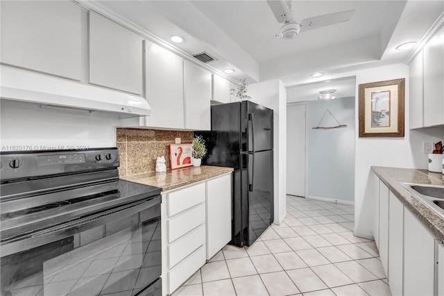 kitchen featuring light tile patterned floors, black appliances, and white cabinets