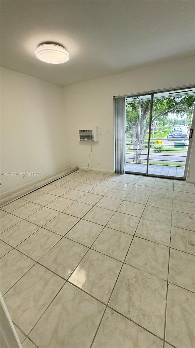 tiled empty room with a wall mounted air conditioner