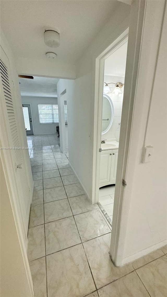 hallway featuring light tile patterned floors and sink