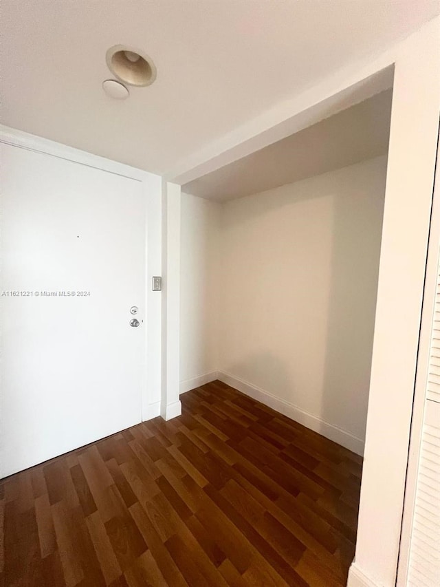 empty room with dark hardwood / wood-style flooring