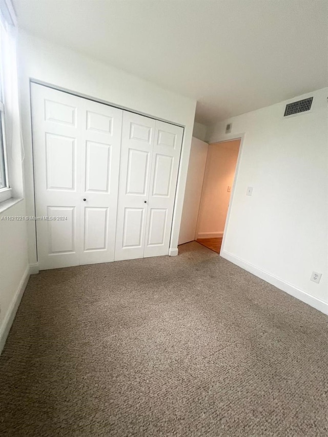 unfurnished bedroom featuring a closet and carpet flooring