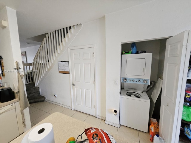 washroom with sink, stacked washing maching and dryer, and light tile patterned flooring