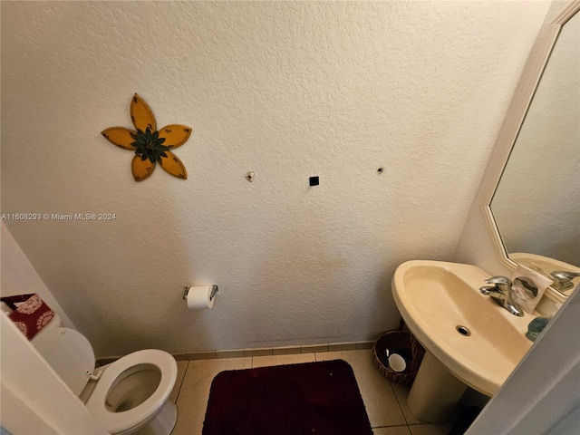 bathroom with sink, toilet, and tile patterned flooring