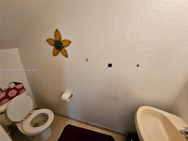 bathroom with sink, toilet, and tile patterned floors