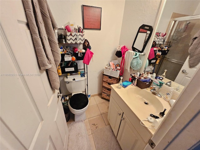 bathroom featuring toilet, an enclosed shower, tile patterned flooring, and vanity