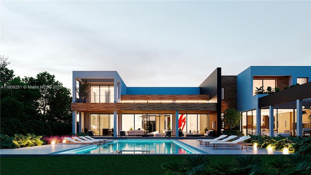 rear view of house with a lawn, a patio, and a balcony