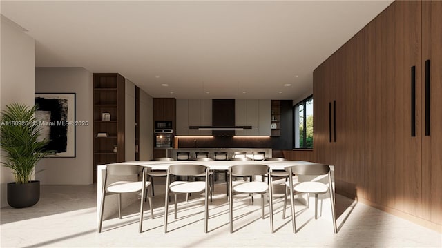 kitchen with black microwave, a breakfast bar, decorative backsplash, and wall chimney exhaust hood