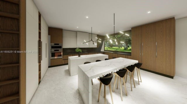 kitchen featuring wall chimney exhaust hood, a breakfast bar area, hanging light fixtures, kitchen peninsula, and double oven