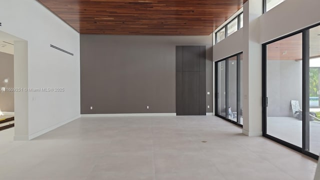 empty room featuring a high ceiling and wooden ceiling