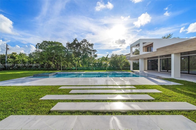 view of swimming pool featuring a patio and a yard