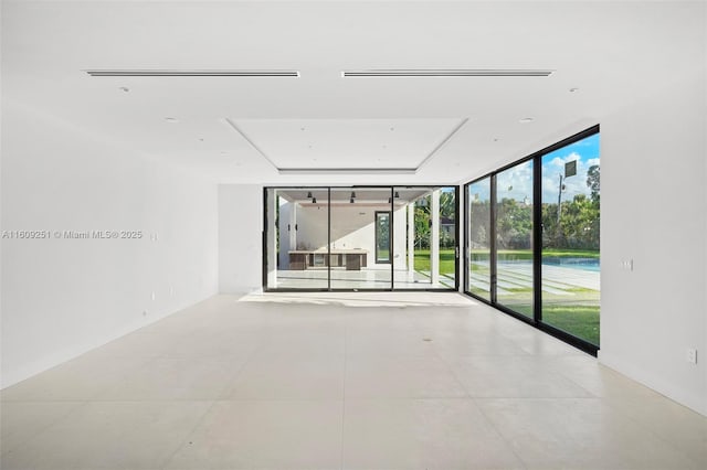 empty room with floor to ceiling windows and light tile patterned floors