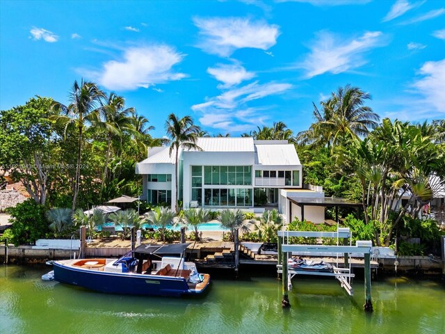 back of property with a water view and a swimming pool