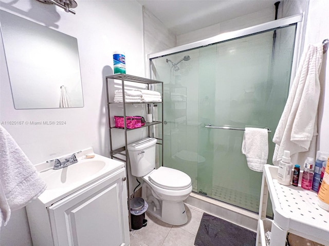 bathroom featuring a shower with shower door, tile patterned floors, vanity, and toilet