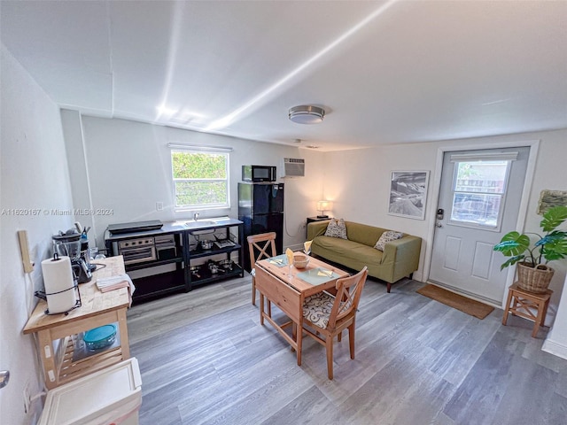 living room featuring hardwood / wood-style floors and a wall mounted air conditioner