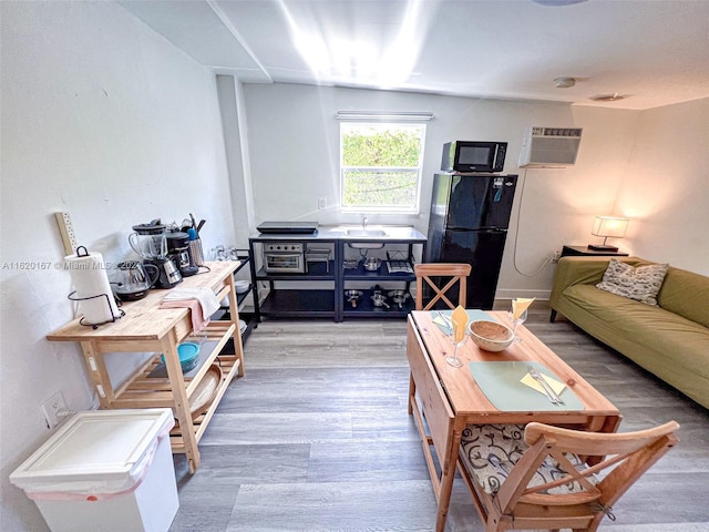 living room featuring sink, wood-type flooring, and a wall mounted AC