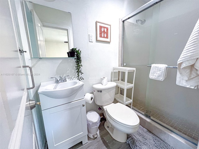 bathroom featuring walk in shower, toilet, hardwood / wood-style floors, and vanity